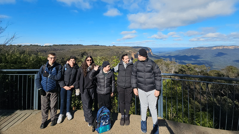 A group of people standing together at a look out in the blue mountains